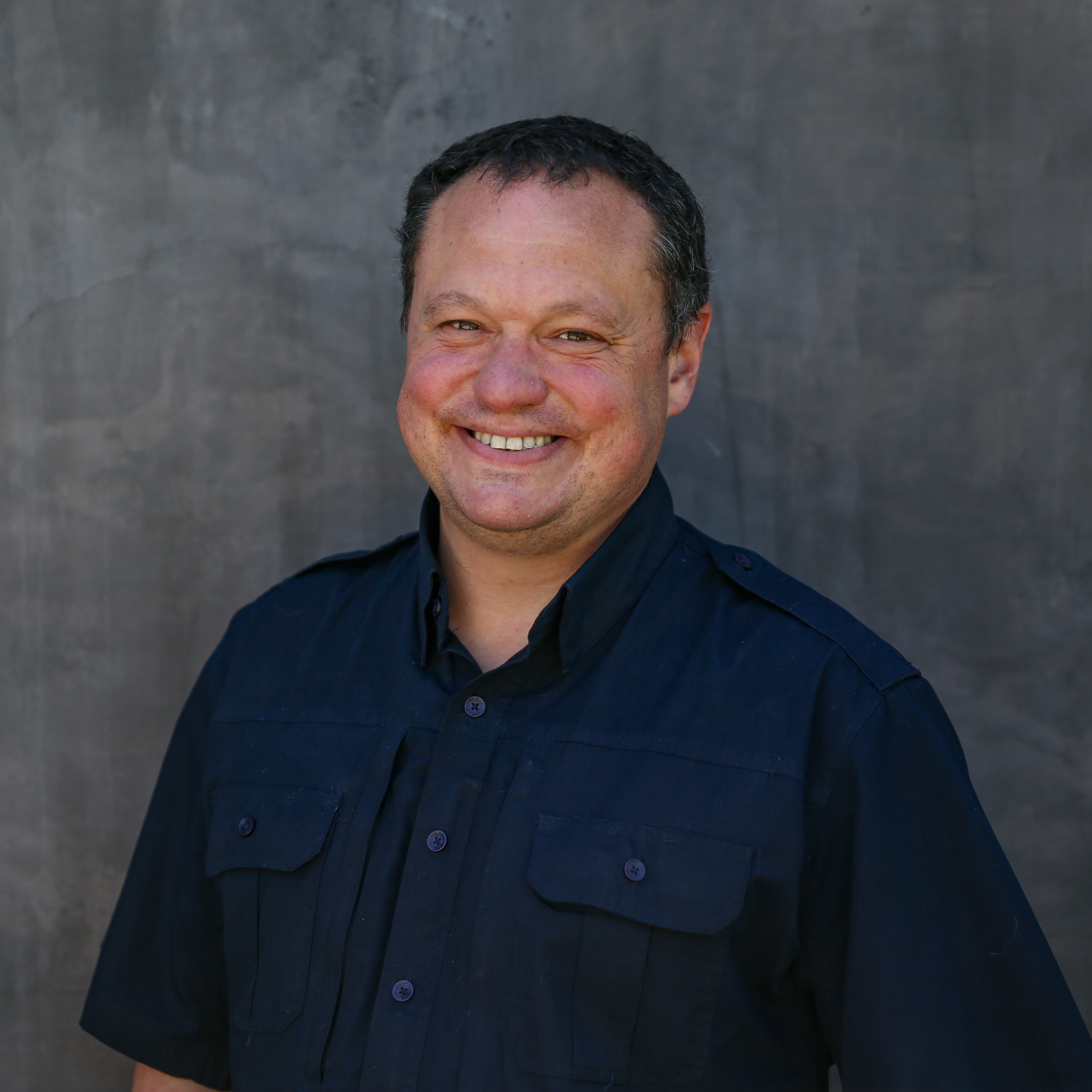 director winemaking standing in front of gray wall